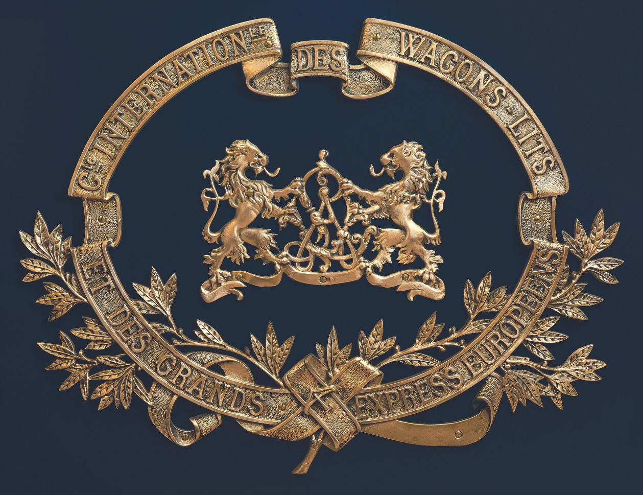 Emblème de la Compagnie des wagons-lits en bronze poli, figurant le monogramme «WL» encadré de deux lions héraldiques, 1929, 63 x 82 cm. P