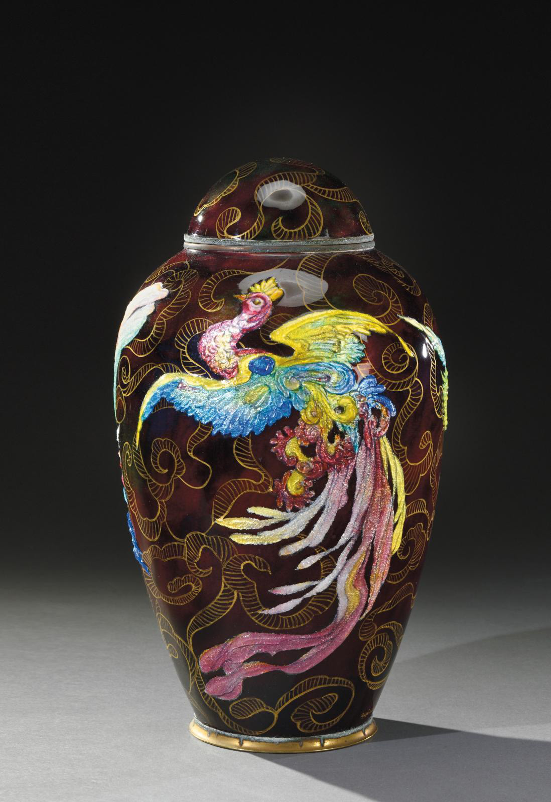 €2,500Lidded copper vase covered with thick polychrome enamel on a purple background, decorated with three birds of paradise on a backgrou