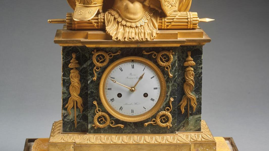 Époque Empire. Pendule en bronze doré et marbre vert de mer, cadran signé de «Ravrio... Les valeureux bronzes du maréchal Suchet