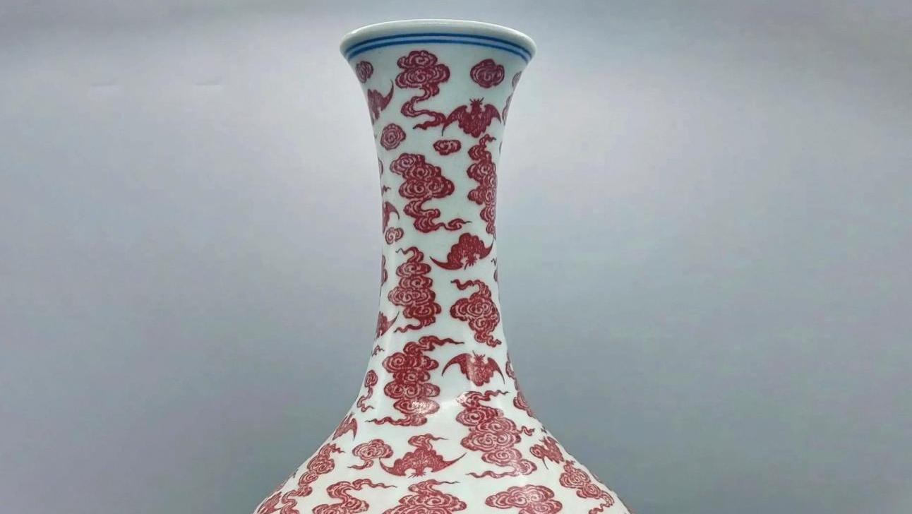 Chine, XVIIIe siècle. Vase à long col et panse galbée sur base évasée, en porcelaine... Nuages et chauves-souris sur une porcelaine de Chine 
