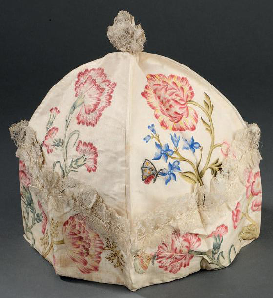 8 750 € Milieu du XVIIIe siècle. Bonnet d’intérieur, à quatre quartiers, en taffetas crème peint à la manière des soies de Chine de fleurs et de papil