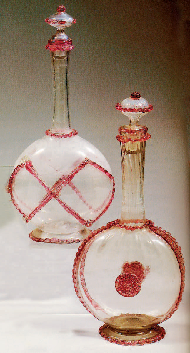 Deux carafes à long col, panse aplatie sur piédouche, avec leur bouchon en verre translucide incolore décoré de filets rouges dentelés et pastilles ro