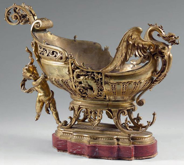 3 020 € Seconde moitié du XIXe siècle. Coupe en bronze doré en forme de traîneau retenu par un amour, un dragon à l’avant, socle en marbre rouge griot