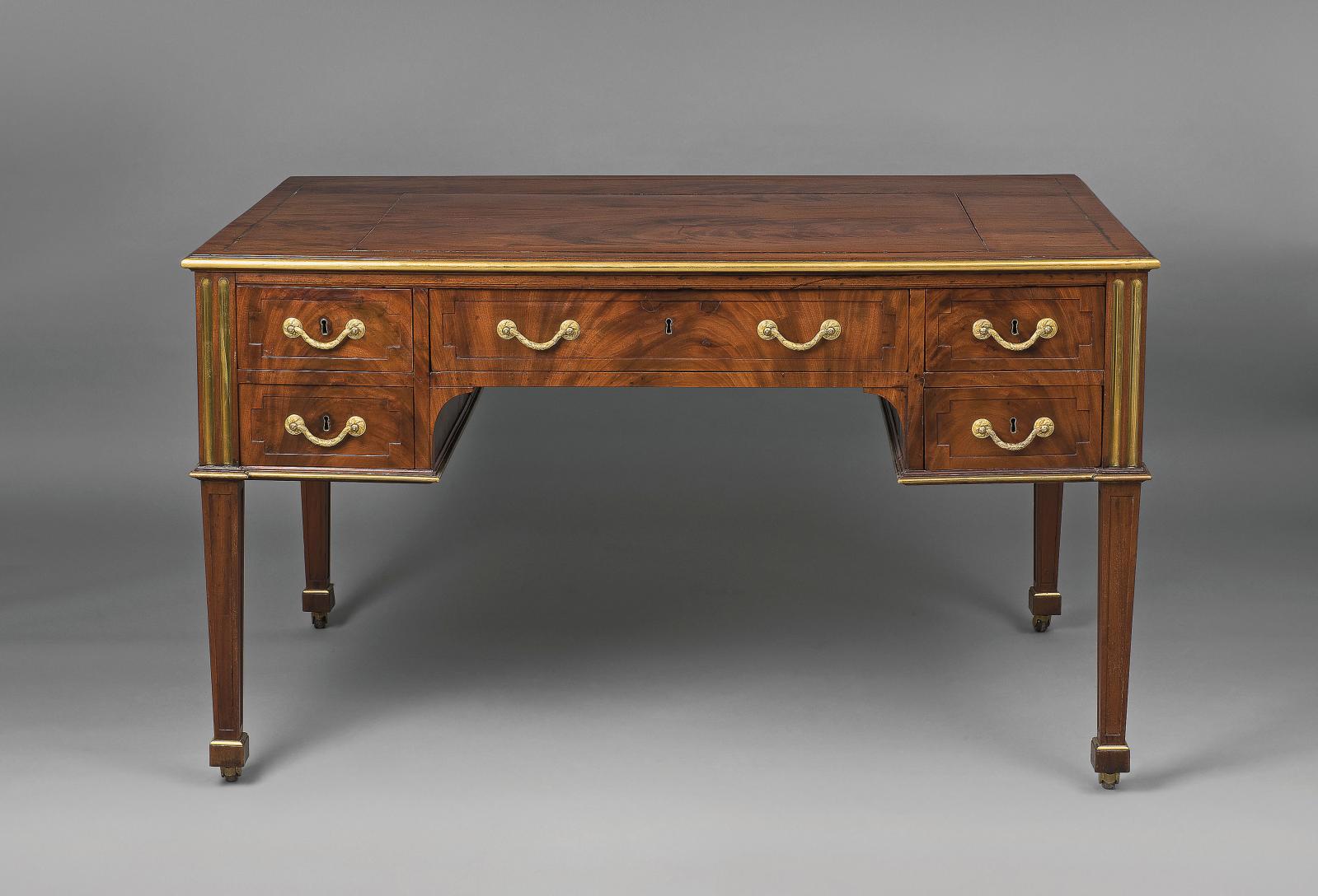 Roentgen en transition Ce bureau plat, sorti de l’atelier de David Roentgen (1743-1807) vers 1780, en placage d’acajou sur âme de chêne, repose sur de
