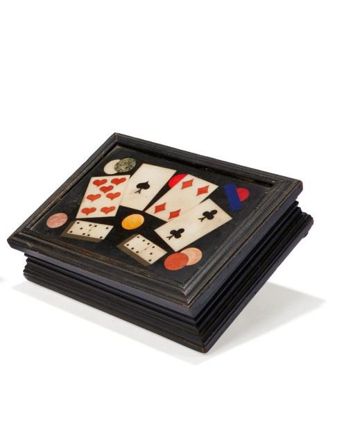 650 €XIXe siècle, boîte à jeu, ornée sur le couvercle d’un décor de cartes à jouer, dés et jetons, bois noirci, marqueterie de pierres dures sur le co