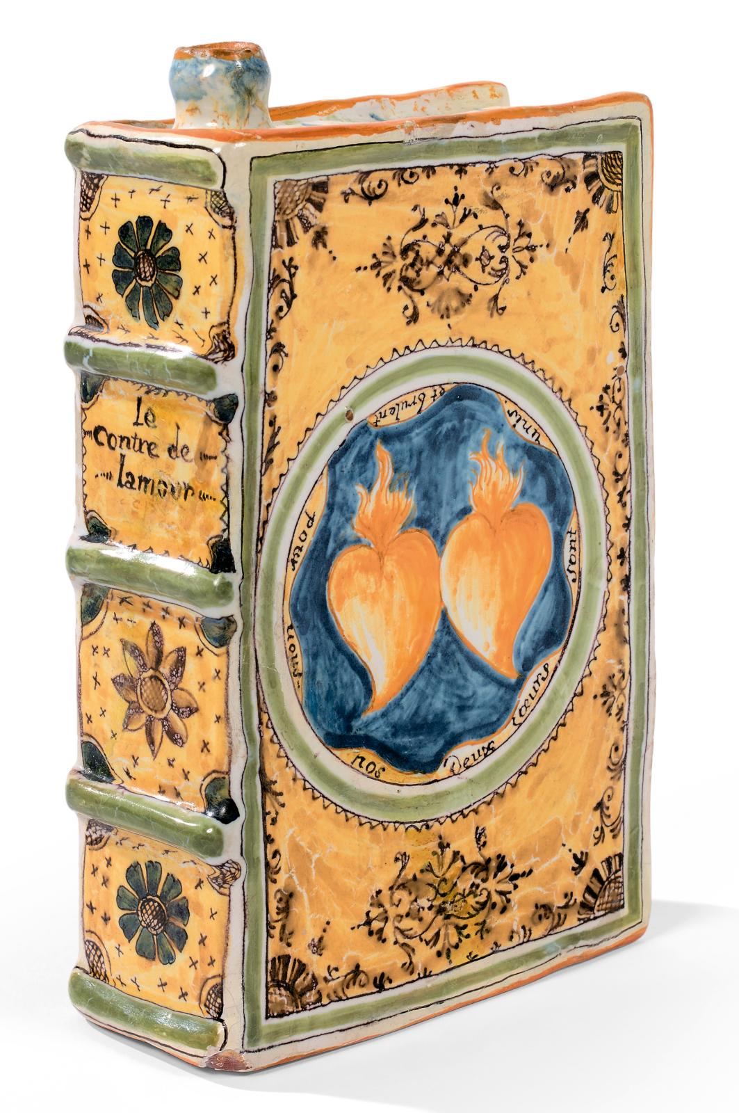 Moustiers, fabrique de Féraud, XVIIIe siècle. Gourde en faïence en forme de livre relié, décor polychrome de deux cœurs enflammés sur une 