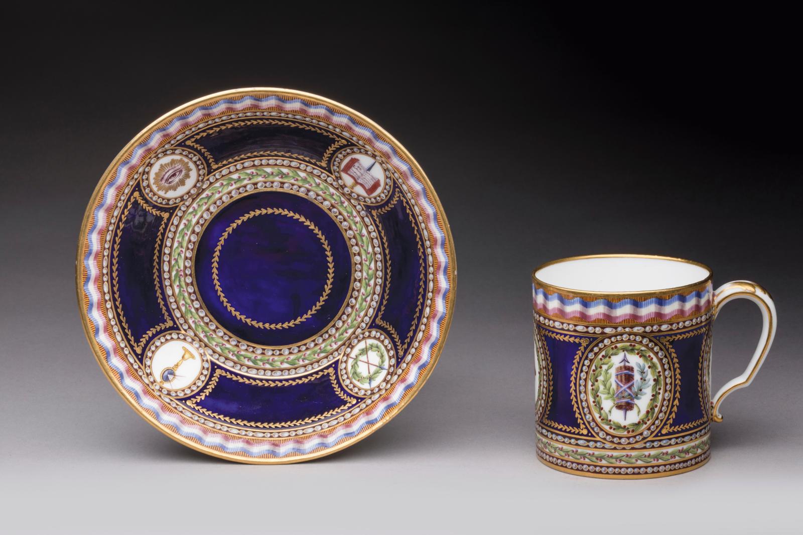 Sèvres, 1794. Tasse « litron » et sa soucoupe, première grandeur, en porcelaine tendre à fond beau bleu, filets or et ruban tricolore, déc