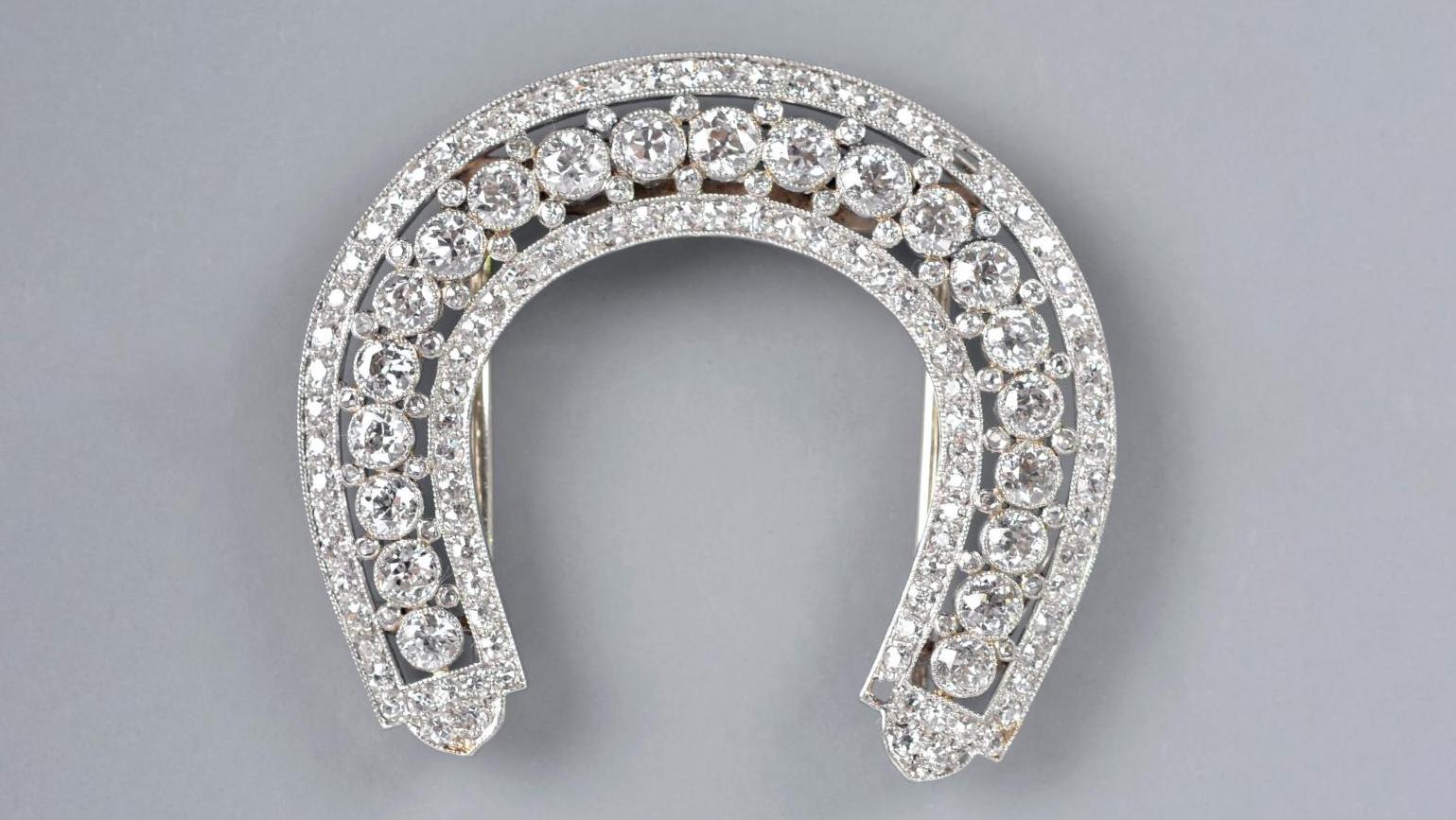 Cartier, vers 1920. Clip en platine et or gris, diamants de taille ancienne en serti... Un porte-bonheur signé Cartier