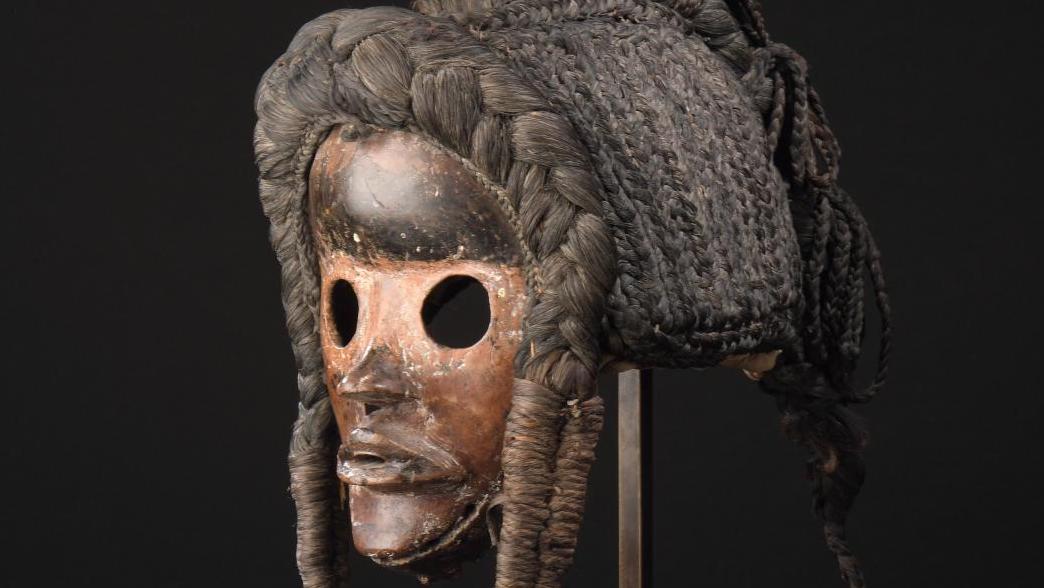 Côte d’Ivoire, Pays dan. Masque royal «go ge» avec sa coiffe, bois à patine d’usage,... Sous le regard des Dans et d'un bouddha