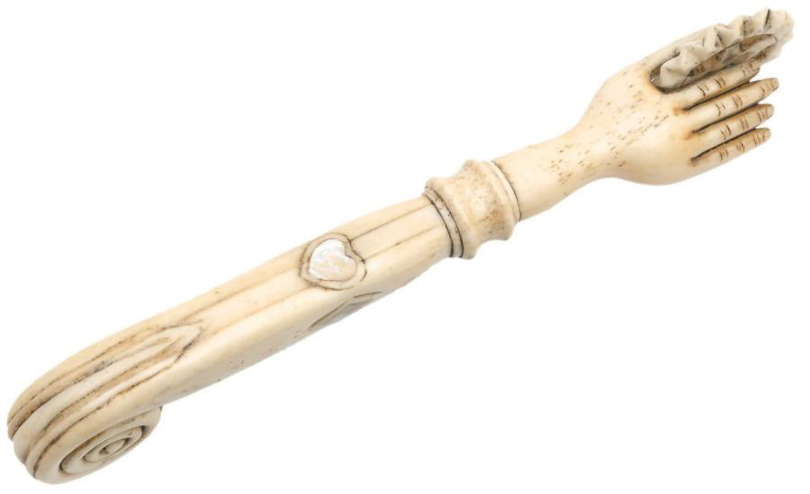 442 € XIXe siècle. Roulette de pâtissier en os de cétacé, tenue par une main sculptée à l’extrémité d’un manche incrusté de nacre et terminé par une v