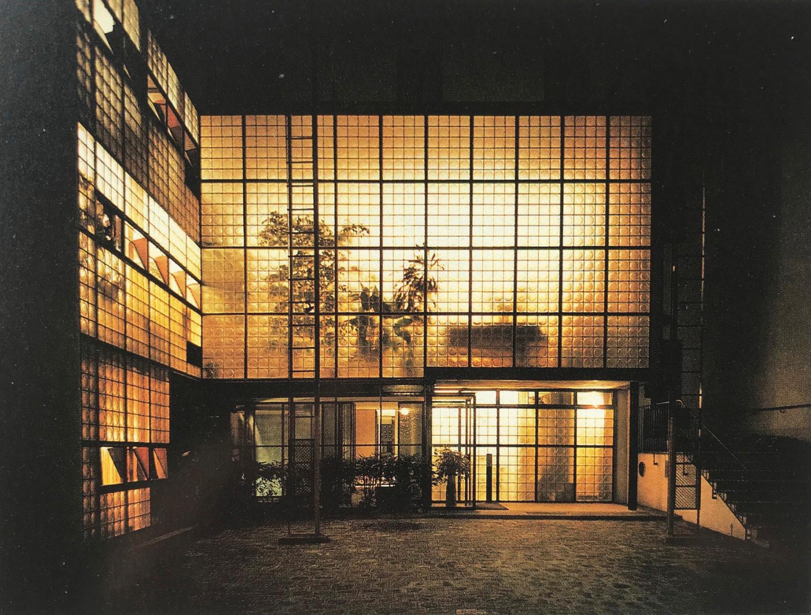 Côté cour, la façade de la maison, pavée de briques de verre, est illuminée la nuit par des projecteurs. Courtesy Marc Vellay