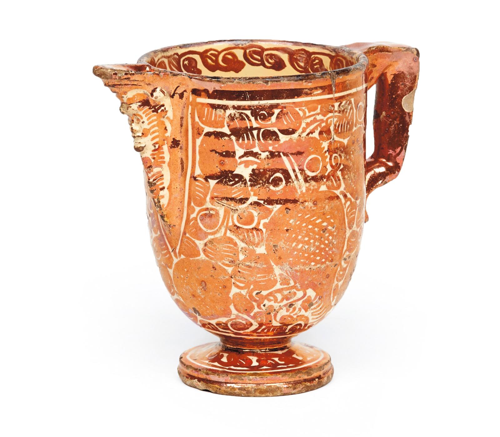 Metallic luster earthenware ewer on a foot, body decorated with tulips and owls in branches, mascaron spout. 17th century, h. 17 cm/6.7 in