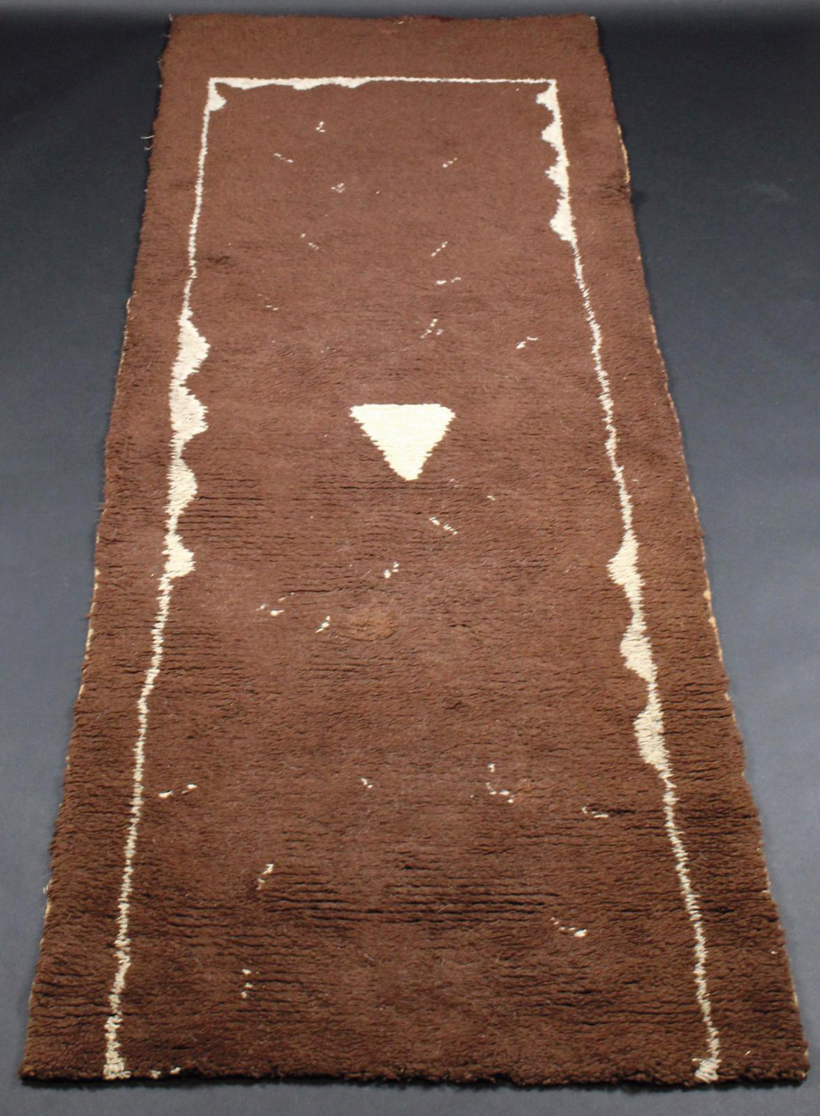 Pierre Legrain (1888–1929), brown wool carpet decorated with white geometric patterns and a triangle in the center, 276 x 100 cm/108.66 x 