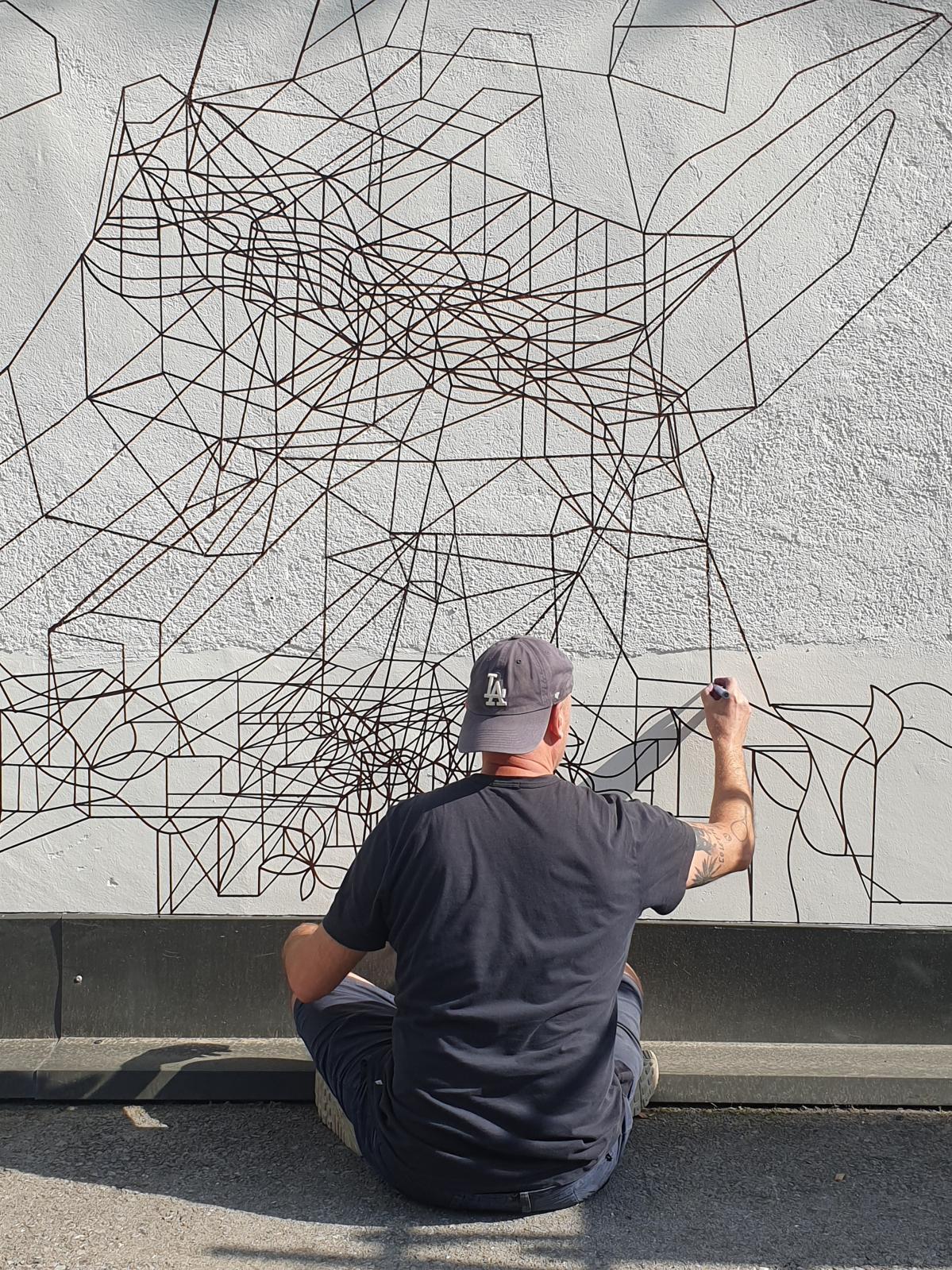 L'artiste réalisant une œuvre murale au Paintmarker sur le bâtiment d’une scierie de Megève en 2021. Photo Laurent Ajina. Courtesy de l’ar